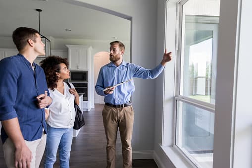 Home inspector walking a couple through a house