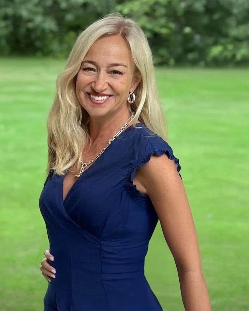 Heidi Laros, Founder and CEO of Cribbed, smiling outdoors in a navy dress
