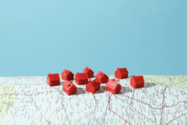 Small red model houses on a blue background