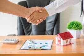 Agent and client shaking hands after signing a contract