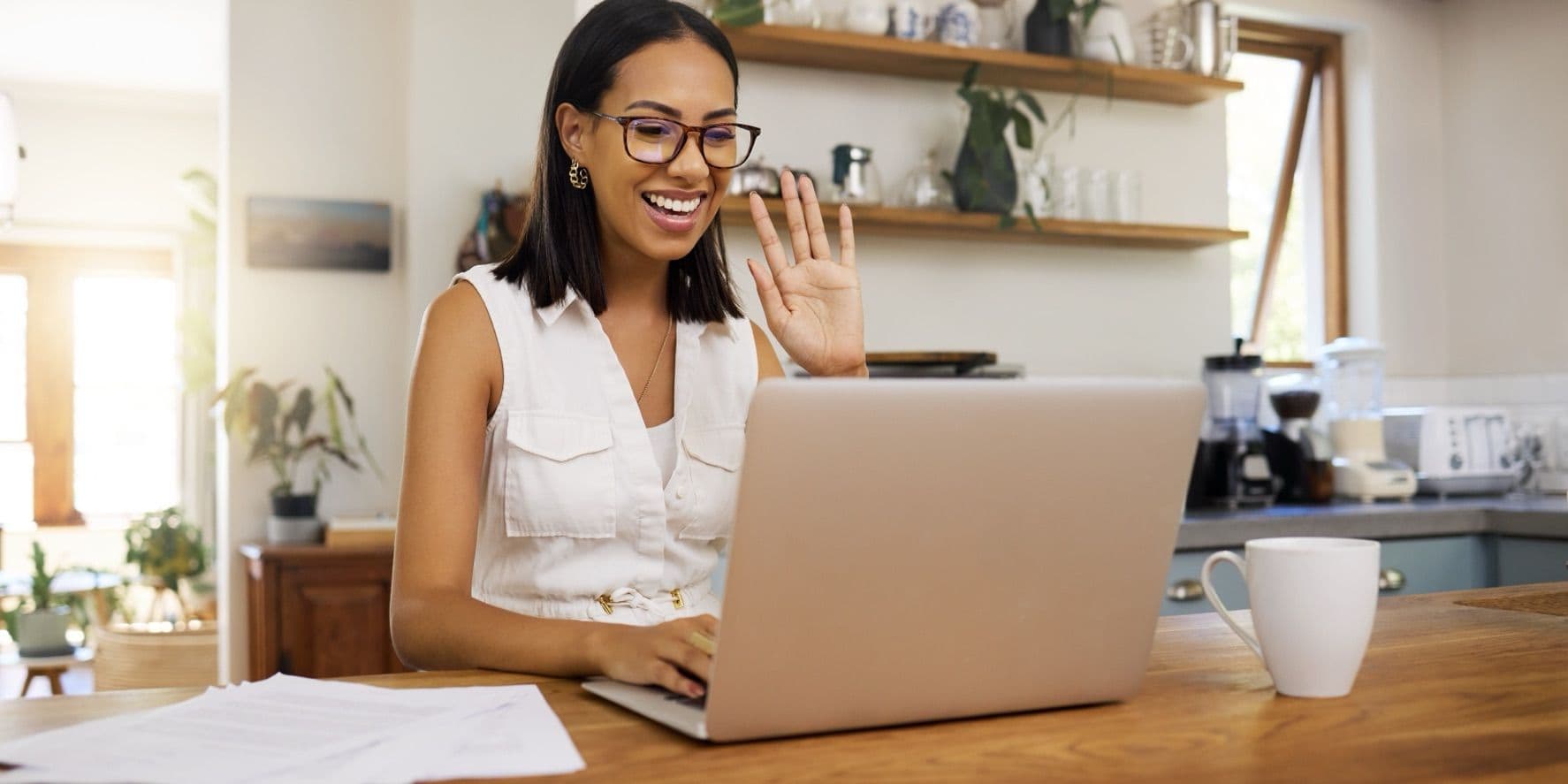 Homeowner smiling at her laptop at the kitchen table