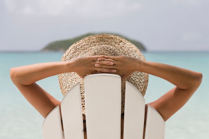 Woman relaxing in a beach chair looking at the ocean