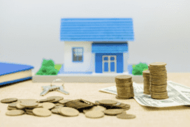 Model house on stacks of coins